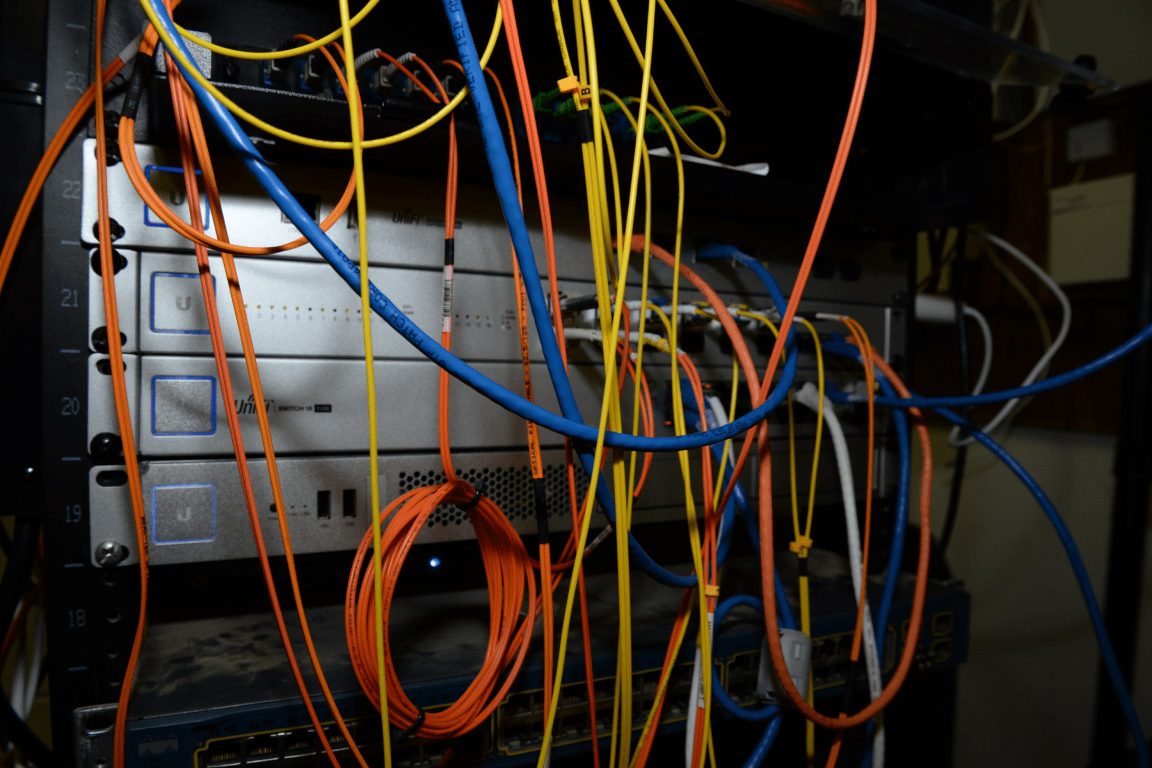 A server rack filled with colorful network cables and equipment